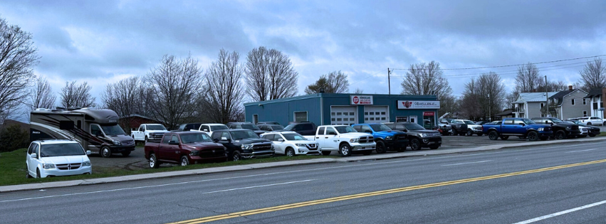 La cour de Les Véhicules JC au 245 boulevard Baril Ouest à Princeville : camions, VR, vans et VUS d’occasion devant le bâtiment